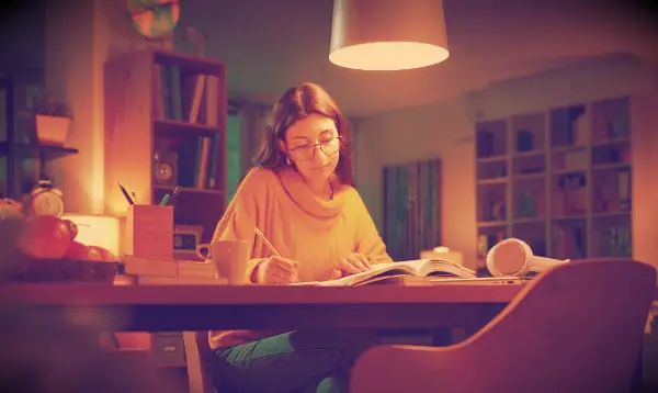A woman focusing on studying in the evening.