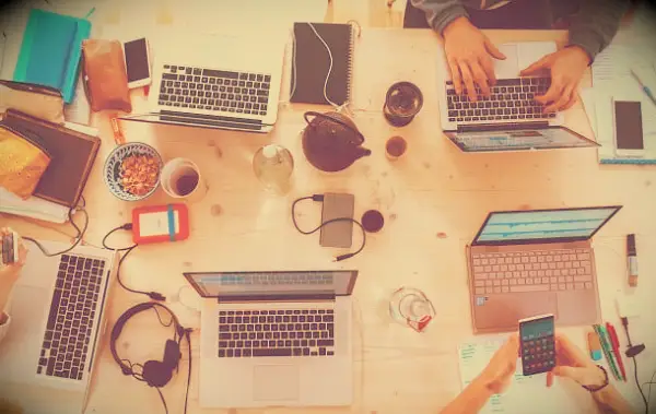 Image of people around a table working at their computers.