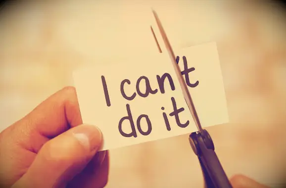 Hands using a scissor to cut away the T in I can